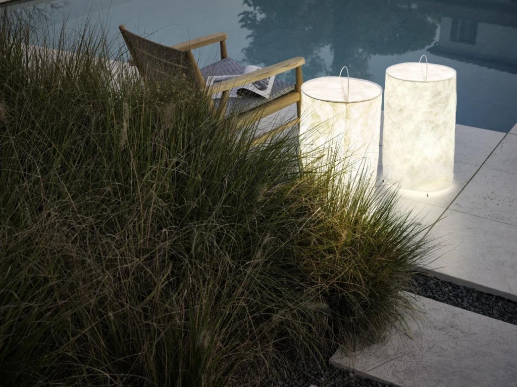 Lampade di design come accento luminoso lungo il bordo piscina.